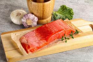 Raw salmon fillet over board photo