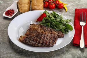 Grilled chuck roll steak with arugula photo