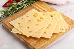 Sliced maasdam cheese with holes photo