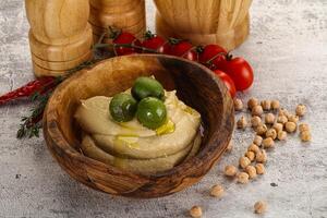 Tasty hummus with green olives photo