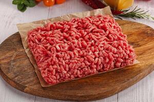 Raw minced beef meat over board photo