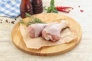 Raw chicken leg over board photo