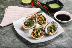 Open half oysters with green onion photo