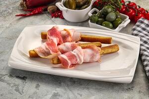 Antipasti - Grissini with pork bacon photo