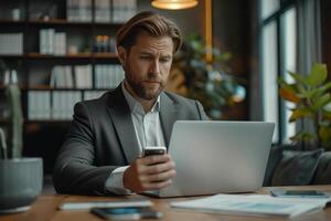 a business suit analyzes financial charts and stock market data on both a smartphone and a laptop photo