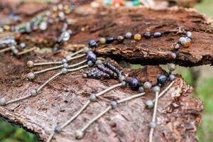 Handcraft necklace made from metal and minerals on a wooden background. Handcraft precious item. Jewelry accessories. photo