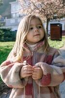 Young Girl Wondering at the Beauty of a Delicate Flower in a Serene Park Setting. photo