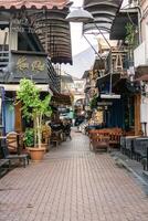 Fethiye, Turkey - December 8, 2022. Charming cobblestone alleyway with vibrant storefronts and outdoor seating in the old town. photo