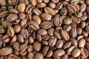 Texture of dark roast coffee beans for background, top view. photo