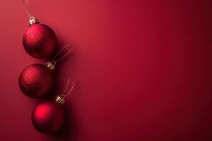 Tres rojo Navidad adornos son colgando desde un rojo antecedentes foto