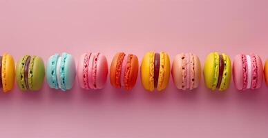 Row of colorful macarons on a soft pastel pink background photo