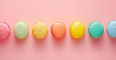 A row of colorful macarons on a pink background photo