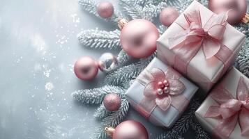 elegante Navidad regalos envuelto con rosado cintas entre escarchado pino ramas y adornos foto