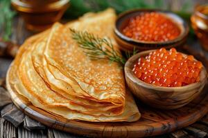 A plate of pancakes with a bowl of caviar on the side photo