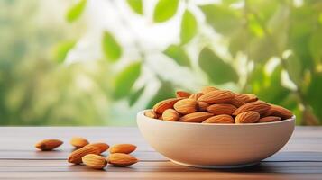 almonds in bowl on wooden table with green background photo