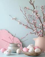 Elegant display of pink spring blossoms in a vase with a bowl of speckled easter eggs photo