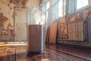 A dehumidifier working in a room with peeling paint, wooden floors, and vintage decor photo