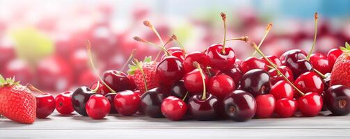 Fresh summer fruits banner with ripe cherries and strawberries on a table photo