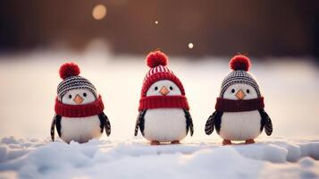 Three toy penguins in knitted hats and scarves stand on the snow close-up. Winter concept photo