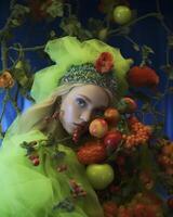 Lush forest fairy portrait amid a cornucopia of fruits and flowers photo