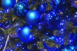Christmas tree branch with snow and blue ornament. New year greeting background. Copy space. photo