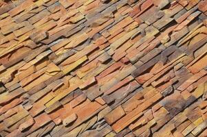 Decorative facing stone imitating a red brick wall. Fragment of the building facade. photo