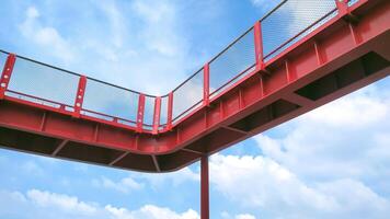 Part of red metal skywalk against white clouds on blue sky background in low angle view photo