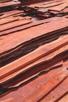 Stack of many redwood wood panels pile on industrial yard in vertical frame, wood construction material background photo