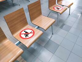 No sitting sign on row of wooden benches in waiting room area, Social distancing concept photo