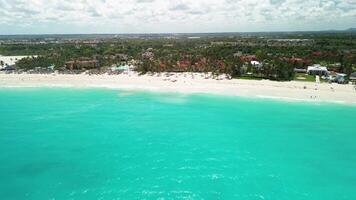 tropicale ricorrere, costa e condomini su Paradiso isola paesaggio. bellissimo caraibico palma spiaggia con palme e bianca sabbia. Hotel su il sponde di il caraibico mare. viaggio per il domenicano repubblica video