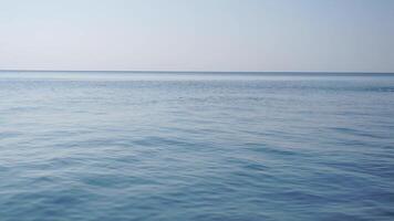 Sea water surface. Low angle view over clear azure sea water. Sun glare. Abstract nautical summer ocean nature. Holiday, vacation and travel concept. Nobody. Slow motion. Weather and climate change video