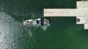 Ferry carrying cars and passengers across the sea, top down aerial drone view. Ferry on the lake, transporting cars. deck of a boat carrying vehicles. video