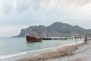 Sailing ship sailing to the shore, marine tourism. Beach holidays on the Black Sea. Fabulous moments of a sunny day. photo