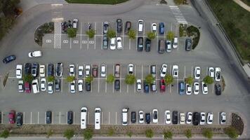 ocupado grande moderno estacionamiento con simétrico carreteras filas de estacionamiento laureles un montón de simetría y colores aéreo ver desde zumbido arriba encima mirando abajo. video