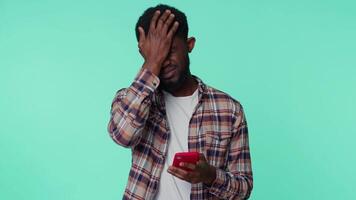 Afrikaanse Amerikaans Mens gebruik mobiel telefoon browsen, verliest, plotseling loterij resultaten, slecht fortuin, verlies video