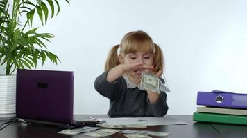 jong kind meisje baas houdt een veel van geld, verheugt zich in de winnen en maakt geld regen verstrooit geld video