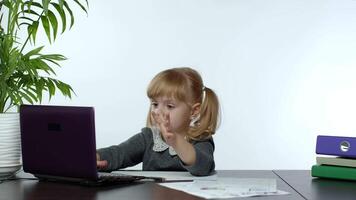 preescolar niño niña distancia en línea aprendizaje a hogar. niño estudiando utilizando digital ordenador portátil computadora video