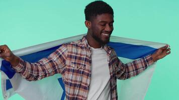 Man waving and wrapping in Israel national flag, celebrating Independence day on gray background video