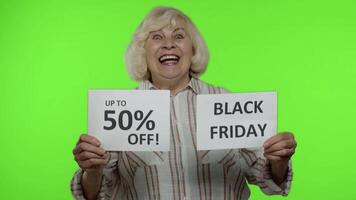 Grandmother showing Black Friday and Up To 50 Percent Off shopping price discount advertisement video