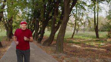 Senior sport man starting smart watch timer, tracking distance and start running in public park video
