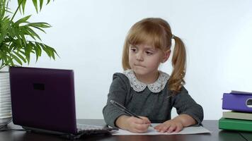 Preschool child girl distance online learning at home. Kid studying using digital laptop computer video