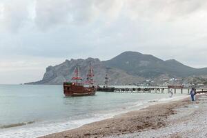 Sailing ship sailing to the shore, marine tourism. Beach holidays on the Black Sea. Fabulous moments of a sunny day. photo