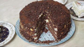 Brown chocolate cake stands on dining table. video