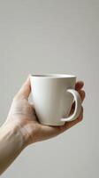 Hand Holding White Ceramic Mug photo