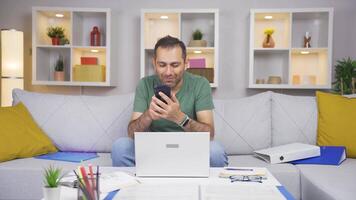 Man working from home enjoys mobile apps on phone. video