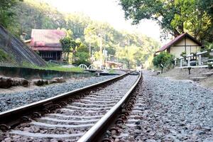 close up railroad railway tracks in the mountain and house building view photo