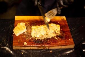 person slicing roast pork beef meat on a cutting board, cut with a knife with top view photo