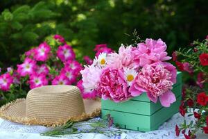 hermosa todavía vida con peonía flores, Clásico taza y sombrero en el mesa. romántico saludo tarjeta para cumpleaños, san valentin, madres día concepto. verano antecedentes con Clásico objetos foto