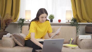 Female student working between paper and laptop. video