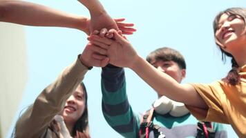 Young happy people put their hands together. video